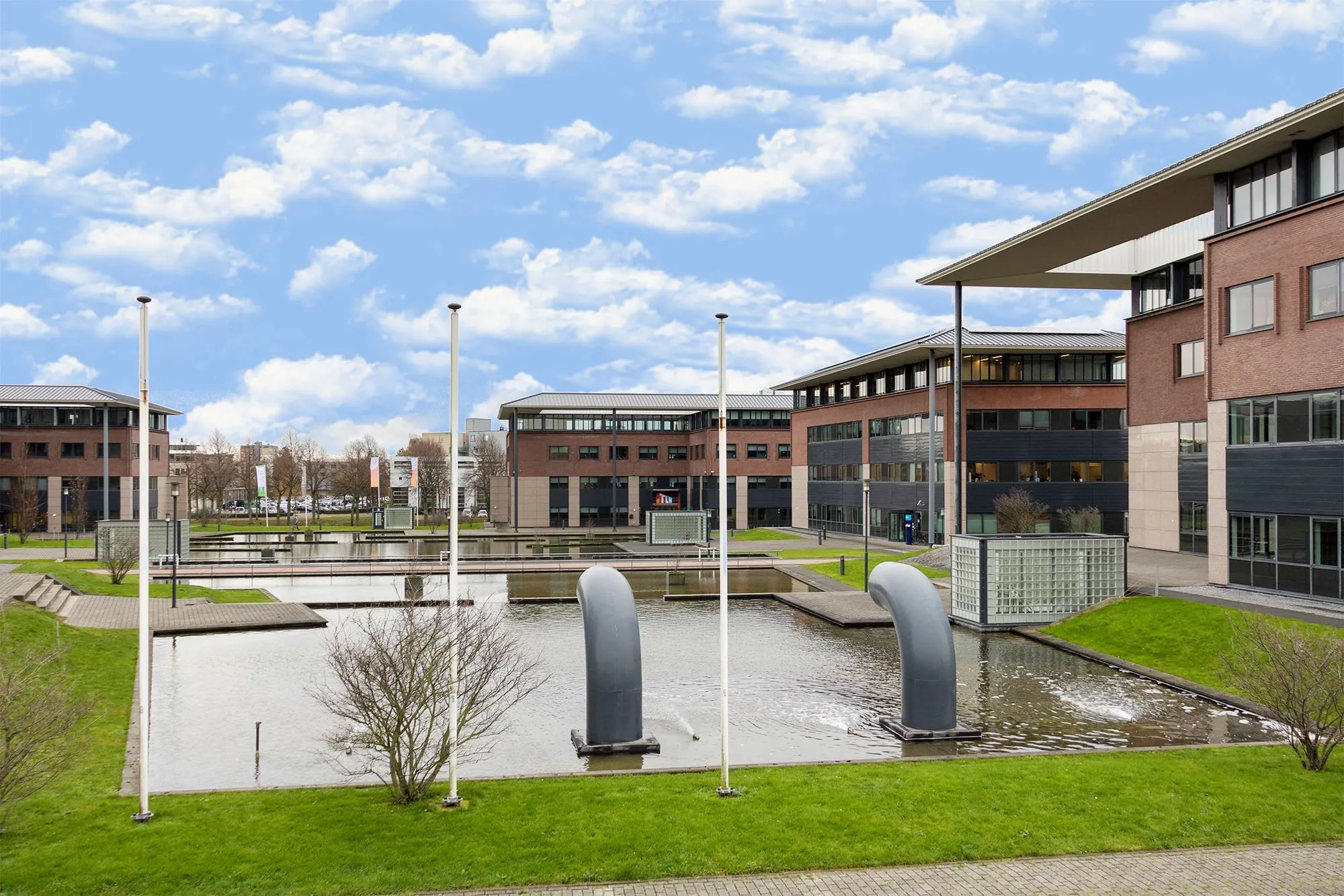Kantoorgebouwen aan de Boris Pasternaklaan met een vijver en moderne sculpturen op de voorgrond.